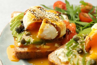 Avokadolu lezzetli sandviçler, haşlanmış yumurta ve somon, yakın plan.