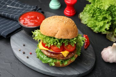 Köfteli lezzetli hamburger, siyah masada servis ediliyor, yakın plan.