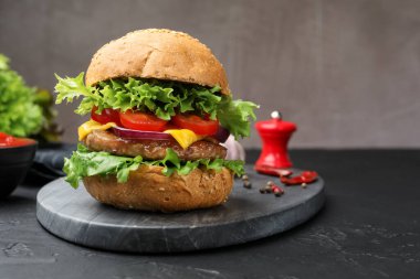 Siyah masada servis edilen köfteli lezzetli hamburger, yakın plan. Metin için boşluk