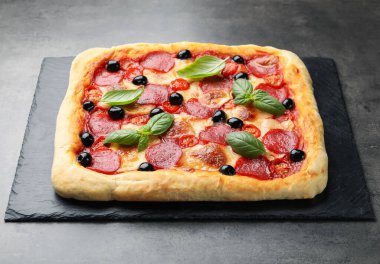 Gri masada fesleğenli ev yapımı pizza.