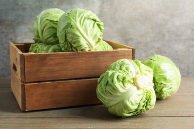 Ahşap masada taze lahana ve sandık.