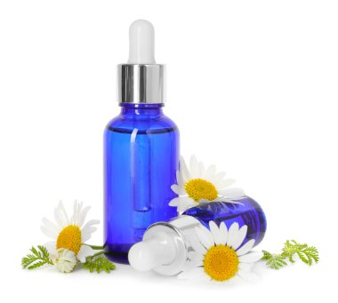 Beyaz üzerine izole edilmiş gerekli yağ ve papatya çiçekleri şişeleri