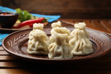 Ahşap masada servis edilen lezzetli khinkali, yakın plan.