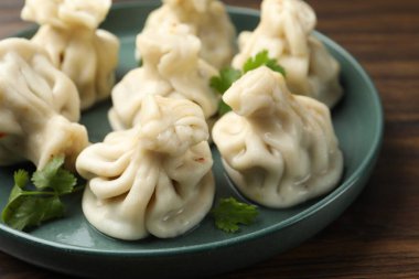 Ahşap masada kişniş soslu nefis hinkali, yakın plan.