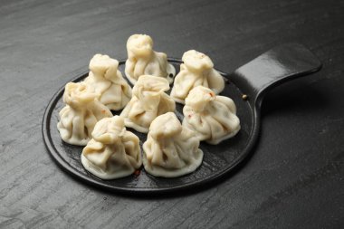 Siyah masadaki baharatlı lezzetli khinkali.