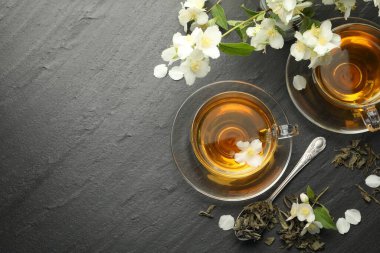 Aromatik yasemin çayı, bira ve çiçekler gri masada, düz yerde. Metin için boşluk