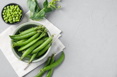 Taze taze taze bezelyeler, gri masada, düz yerde. Metin için boşluk