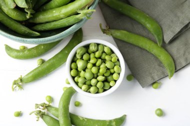 Taze taze bezelyeler beyaz ahşap masada, düz yatıyordu.