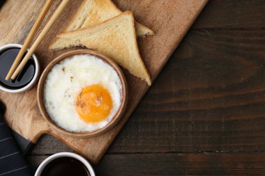 Tabakta yarı haşlanmış yumurta, soya sosu, yemek çubukları, kahve ve ahşap masada kızarmış ekmek, düz yatak. Metin için boşluk