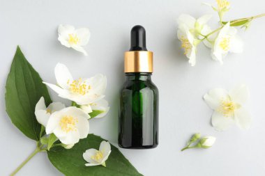 Kozmetik ürünleri ve yasemin çiçekleri arka planda, düz yatıyordu