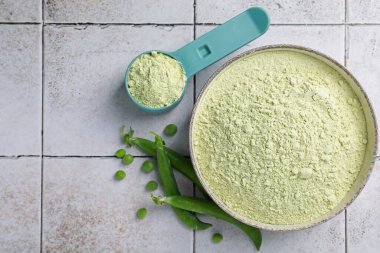 Protein tozu ve yeşil bezelyeler açık renkli masada, düz yerde. Metin için boşluk