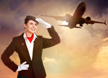 Gün batımına karşı gülen hostes uçak ve bulutlarla