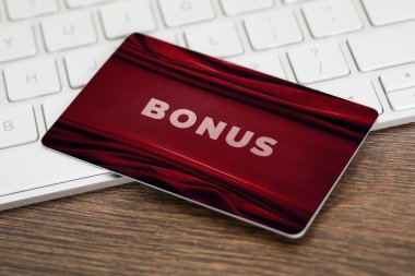 Şık tasarımı olan bonus kart ve ahşap masada bilgisayar klavyesi