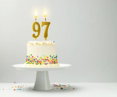 Yanan mumlar ve hafif arka planda serpiştirilmiş şekerlemelerle nefis bir pasta, yazı için boşluk. 97. Doğum günü veya diğer özel günler