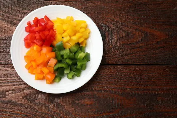 Ahşap masada renkli dolmalık biberler, üst manzara. Metin için boşluk