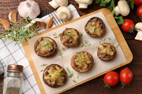 Lezzetli mantarlar ve ahşap masa üzerindeki ürünler.