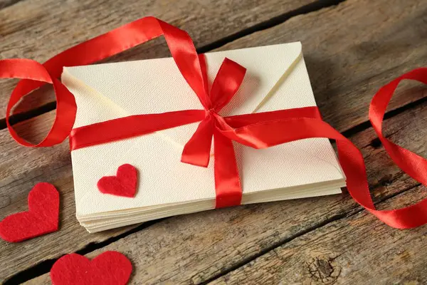 Aşk mektupları ve kağıt kalpler ahşap masada, yakın plan.