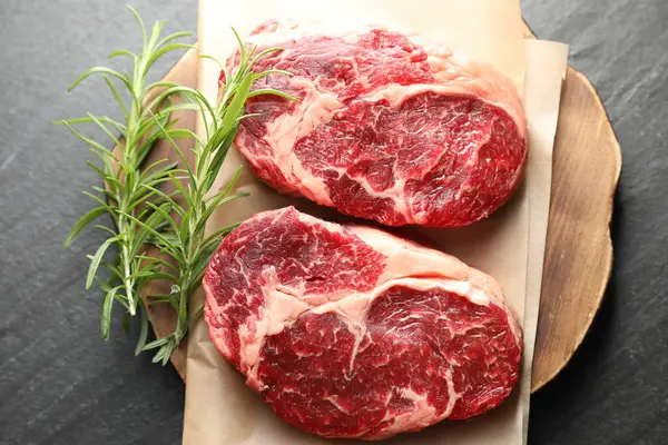 Siyah masada çiğ et ve biberiye parçaları.