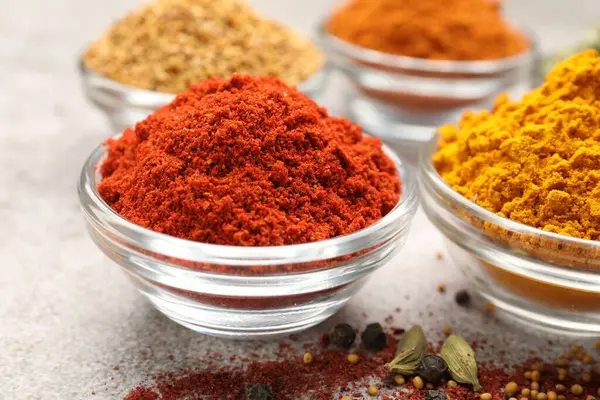 Açık gri masada farklı aromatik baharatlar, yakın plan.