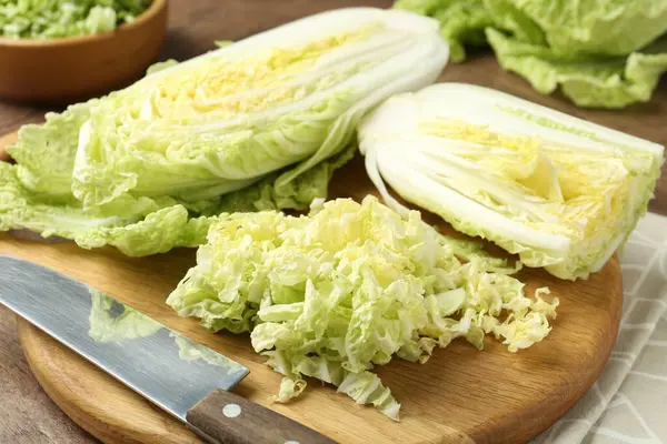 Taze Çin lahanaları ve bıçak ahşap masada, yakın plan.