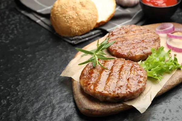 Siyah masada leziz hamburger köfteleri ve baharatlar, yakın plan. Metin için boşluk