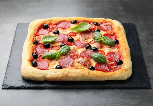 Gri masada fesleğenli ev yapımı pizza.