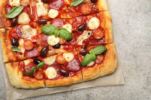 Gri masada ev yapımı lezzetli bir pizza, üst manzara.