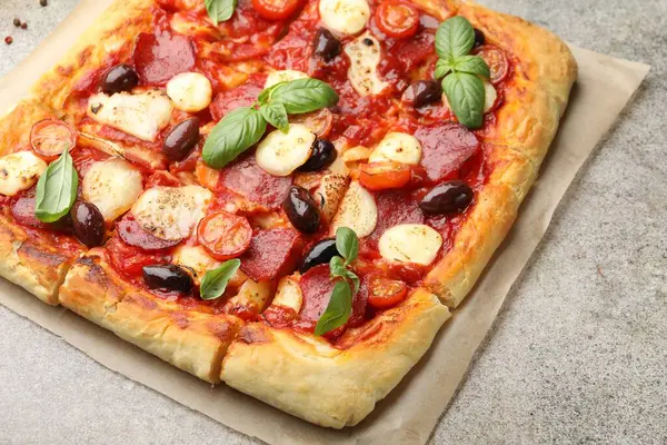 Gri masada ev yapımı lezzetli bir pizza, yakın plan.