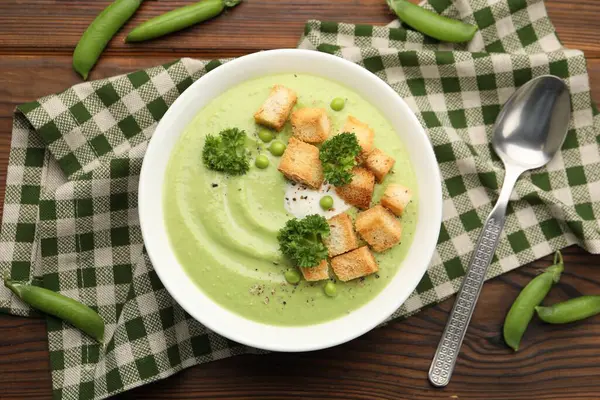 Tahta masada servis edilen kızarmış ekmek ve brokoli ile bezelye kremalı leziz çorba.