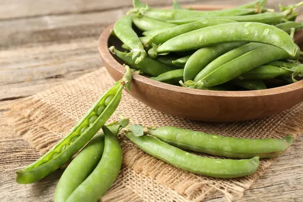 Taze taze bezelyeler ahşap masada, yakın plan.