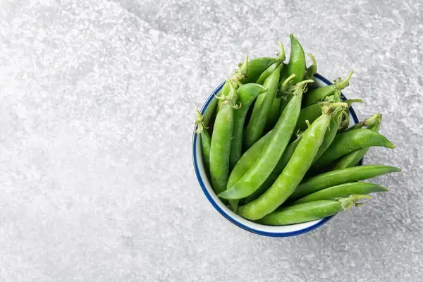 Gri masada taze taze taze bezelyeler, üst manzara. Metin için boşluk