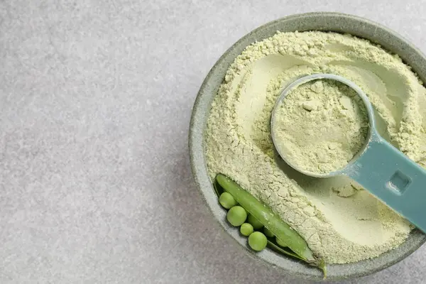 Protein tozu ve açık gri masada taze bezelyeler, üst manzara. Metin için boşluk