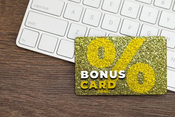 Şık tasarımı olan bonus kart ve tahta masa üzerinde bilgisayar klavyesi, üst görünüm