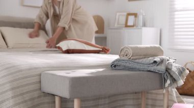 Yastıkları odadaki yatağa yerleştiren kadın, seçici odaklanma. Ev tekstili