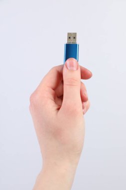 Açık gri arka planda modern flash diski olan adam, yakın plan.