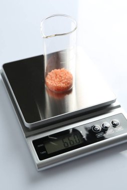 Beyaz arka planda numune şişesi olan laboratuvar ölçeği, yakın plan.