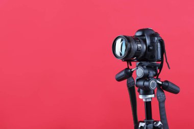 Kırmızı arkaplanda modern profesyonel video kamera, metin için boşluk