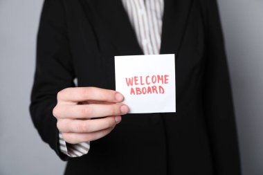 İnsan Kaynakları Yöneticisi 'nin elinde yapışkan kelimeler var. Gri arkaplanda hoş geldiniz, yakın plan.