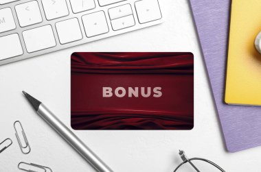 Beyaz masada şık tasarımı, kırtasiyesi ve bilgisayar klavyesi olan bonus kart, düz konum