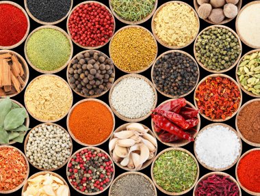 Siyah arka plandaki kaselerde farklı aromatik baharatlar dizisi.