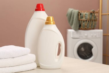 İçerideki ahşap masada yumuşatıcı ve havlu şişeleri, metin için yer.