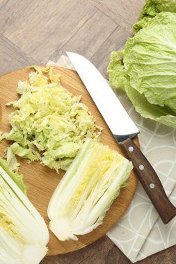 Taze Çin lahanaları ve bıçak ahşap masada, düz yatıyordu.