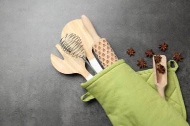 Fırın eldivenindeki farklı mutfak aletleri ve gri masadaki anason yıldızları, düz yatıyordu.