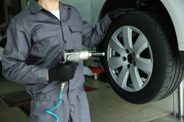 Tamirci araba servisinde lastik değiştiriyor, yakın plan.