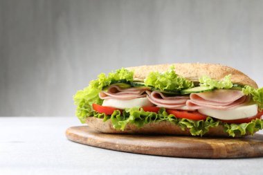 Jambonlu ve sebzeli baget sandviç açık gri masada, yakın plan.