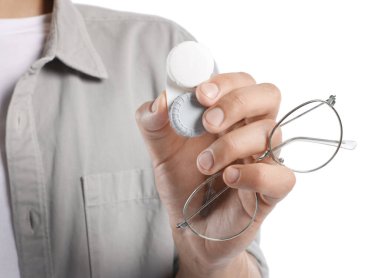 Beyaz arka planda gözlüklü ve kontak lensli adam, yakın plan.