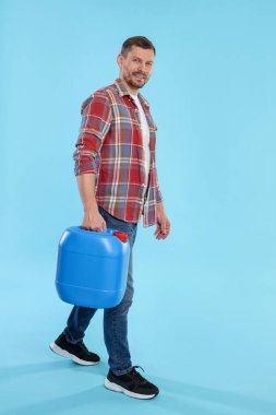 Açık mavi arkaplanda plastik kutu tutan adam, metin için boşluk