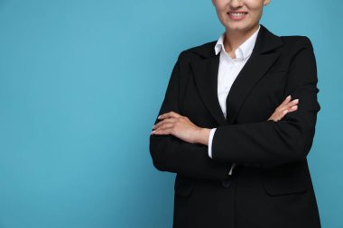 Açık mavi arka planda takım elbiseli, kendine güvenen iş kadını, yakın plan. Metin için boşluk