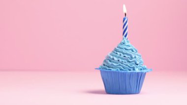 Kekin içinde yanan mum pembe arkaplanda, metin için boşluk