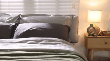 Yumuşak çarşafları ve odada battaniyeleri olan rahat bir yatak, kamera hareket ediyor. Ev tekstili